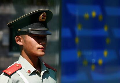 Un guarda chino frente a una bandera de la UE.