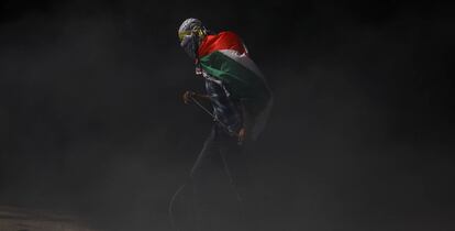 Un manifestante con la bandera de Palestina sobre sus hombros.
