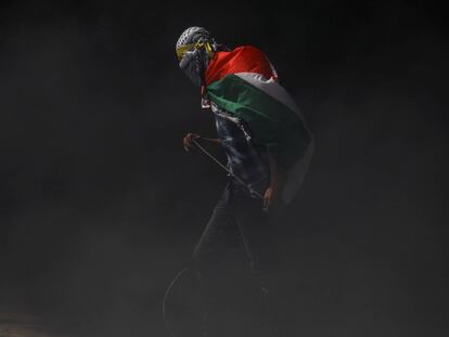 Un manifestante con la bandera de Palestina sobre sus hombros.