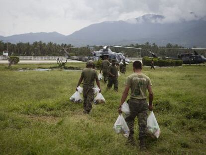 Militares suben a los helicópteros alimento para las comunidades más afectadas por la tormenta tropical Manuel en Pie de la Cuesta.