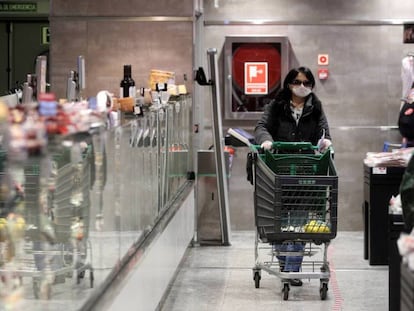 Varias personas hacen la compra en un supermercado, en Madrid.