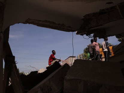 Um grupo de pessoas remove escombros em uma rua de Los Cayos