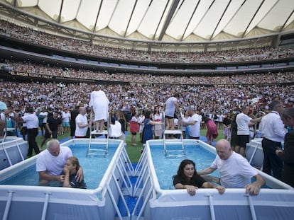 Dos mujeres son bautizadas en un evento organizado por los Testigos de Jehová.