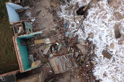 Vista aérea de un hombre recogiendo escombros de una casa que se derrumbó el día anterior en la playa de Atafona (Brasil).