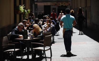 Un camarero sirve en una terraza en Madrid