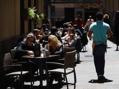 Un camarero sirve en una terraza en Madrid