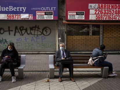 Un grupo de personas sentado fuera de las tiendas cerradas, el pasado 2 de septiembre de 2021 en Santiago de Chile.