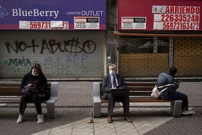 Un grupo de personas sentado fuera de las tiendas cerradas, el pasado 2 de septiembre de 2021 en Santiago de Chile.