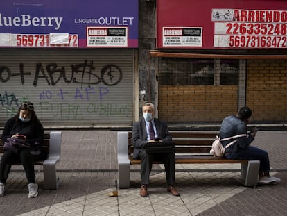 Un grupo de personas sentado fuera de las tiendas cerradas, el pasado 2 de septiembre de 2021 en Santiago de Chile.