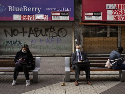 Un grupo de personas sentado fuera de las tiendas cerradas, el pasado 2 de septiembre de 2021 en Santiago de Chile.