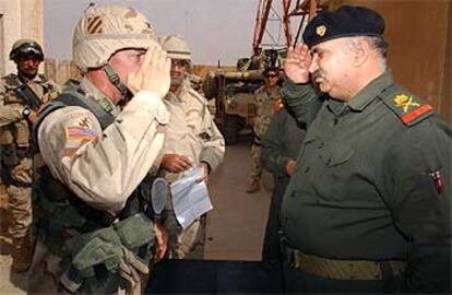 El coronel de EE UU Curtis Potts (izquierda), saluda al general iraquí Mohamed Jaraui, tras firmar éste su rendición