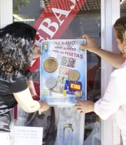 Fotografía facilitada por el Ayuntamiento de El Álamo de la directora de Comercio de la Comunidad de Madrid, Inés Gómez-Acebo (i), y su alcaldesa, Natalia Quintana (d), durante la presentación de una iniciativa que desde hoy y hasta el final de septiembre permitirá a sus vecinos y visitantes gastar en tiendas o en bares con la antigua peseta.