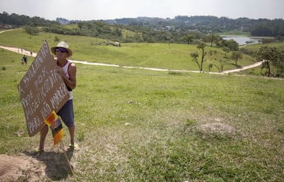 Um dos moradores segura cartaz de protesto à construção de casas populares no terreno do Parque dos Búfalos.