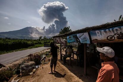 Residentes de Indonesia miran al volcán Mount Sinabung arrojando ceniza cerca de Tiga Pancur, Sumatra del Norte (Indonesia).