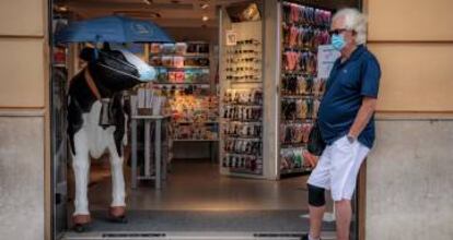 Una persona espera a la entrada de un comercio en Valencia.