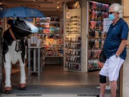 Una persona espera a la entrada de un comercio en Valencia.