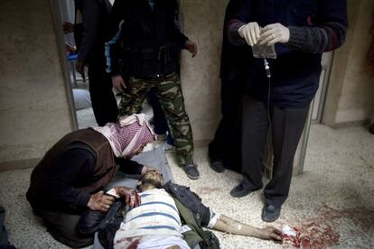 Un rebelde sirio es atendido por sus compañeros tras ser herido durante los combates con el Ejército sirio.