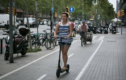 Una mujer circula con un patinete electrico por Barcelona.