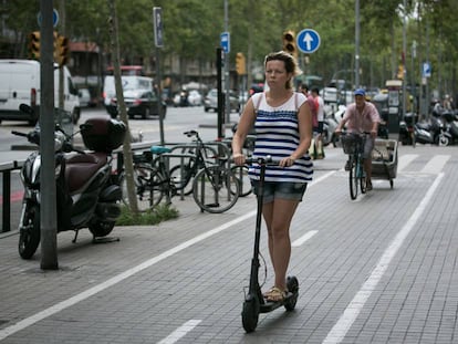 Una mujer circula con un patinete electrico por Barcelona.