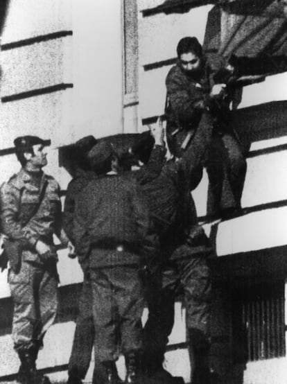 Un guardia civil sale por una ventana de la oficina de prensa del Congreso de los Diputados para entregarse a la policía, tras fracasar el intento de golpe de Estado. Que los guardias civiles de rango inferior al de teniente no serían juzgados fue una de las condiciones que Tejero y Pardo Zancada habían incluido en las condiciones de su rendición. Se le conoce como el 'pacto del capó', ya que se firmó sobre el capó de un Land Rover.