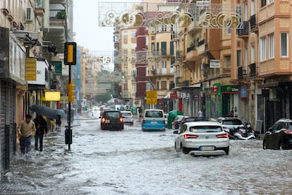 Varias personas caminaban por el barrio de El Perchel (Málaga) este miércoles durante la dana.