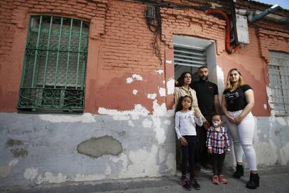 La familia, fotografiada frente a la puerta de su vivienda, en Vallecas.