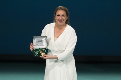 María Rosa García 'Niña Pastori'  enseña su medalla al público congregado en el teatro de la Maestranza.