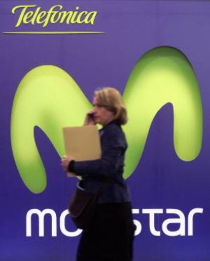 Una mujer habla por telefono junto a un cartel de Movistar. EFE/Archivo