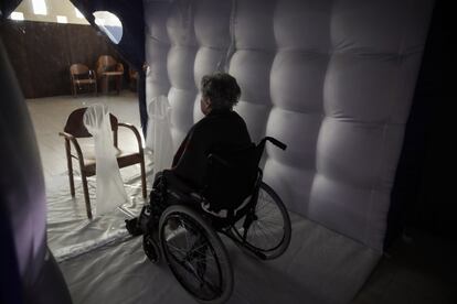 Caterina Salvi, de 90 años, espera una visita dentro de un túnel protector de plástico hinchable en la residencia de ancianos Martino Zanchi de Alzano Lombardo, en el norte de Italia. Este tunel se instaló para que los residentes de la residencia pudieran respetar las restricciones contra la covid sin dejar de tener contacto personal con sus familiares.