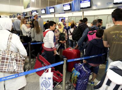 Los refugiados facturan sus pertenencias en el aeropuerto de Atenas poco antes de despegar rumbo a Madrid.