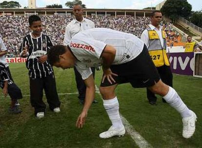 Ronaldo salta al campo antes del inicio del partido y se agacha para tocar el césped.