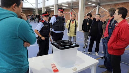 Dos mossos ante una urna de un colegio durante la jornada del referéndum del 1 de octubre en Cataluña. c