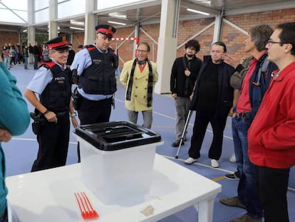 Dos mossos ante una urna de un colegio durante la jornada del referéndum del 1 de octubre en Cataluña. c