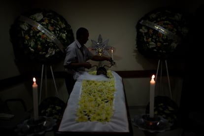 A hearse driver in São Paulo helps prepare a body for burial.