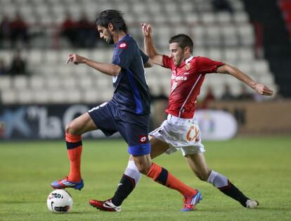 El deportivista Lassad se lleva el balón perseguido por Seoane.