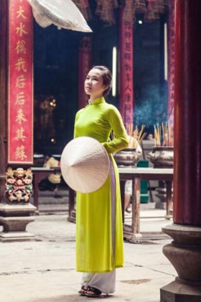 Una joven ataviada con el 'lao dai', la vestimenta tradicional vietnamita, en un templo de Saigón.