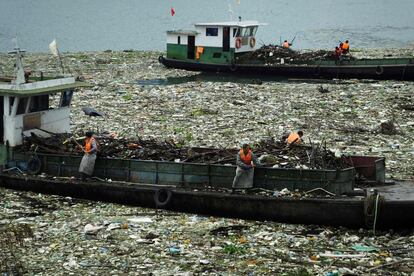 Varios trabajadores retiran la basura del río Yangtsé en Yichang, en la provincia de Hubei, en el centro de China.