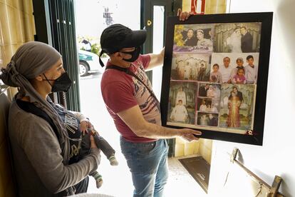 Rachid El Yagoubi y su mujer, Fátima Maknassi, en el portal de su casa con sus fotos de boda tras ser desahuciados.