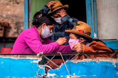 Una familia en Pamplona Alta, a las afueras de Lima (Perú), se prepara para salir con mascarillas.