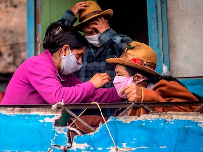 Una familia en Pamplona Alta, a las afueras de Lima (Perú), se prepara para salir con mascarillas.