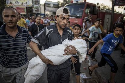 Un hombre palestino lleva en brazos a un niño muerto en uno de los ataques de Israel sobre la Franja de Gaza.