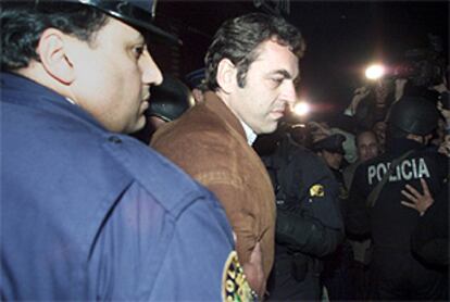Dante Peirano es escoltado por la policía tras testificar en un tribunal.