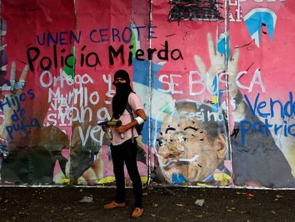 Un manifestante, frente a un mural con pintas contra Ortega. 