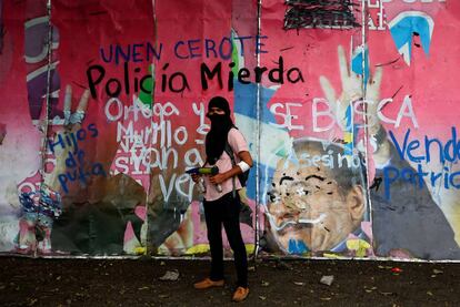 Un manifestante, frente a un mural con pintas contra Ortega. 