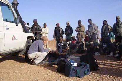 Un miembro de Médicos Sin Fronteras atiende a unos subsaharianos deportados por Marruecos al desierto en la frontera con Argelia.