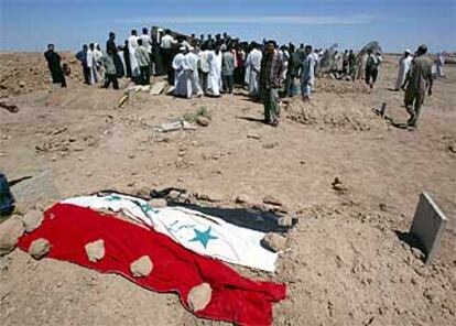 La tumba de una de las víctimas del tiroteo, cubierta por una bandera iraquí, en el cementerio de Faluja.
