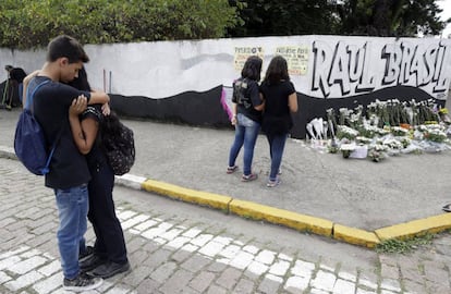 Estudiantes se abrazan afuera de la escuela pública un día después del tiroteo. Los alumnos colocaron una ofrenda en honor a las víctimas. 
 