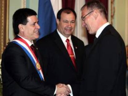 El comisario de Desarrollo de la Unión Europea, Andrés Piebalgso (d), saluda al nuevo presidente paraguayo, Horacio Cartes (i), junto a su vicepresidente, Juan Afara (c), tras la ceremonia de investidura de Cartes, en Asunción (Paraguay).
