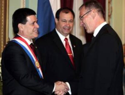 El comisario de Desarrollo de la Unión Europea, Andrés Piebalgso (d), saluda al nuevo presidente paraguayo, Horacio Cartes (i), junto a su vicepresidente, Juan Afara (c), tras la ceremonia de investidura de Cartes, en Asunción (Paraguay).