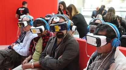Varias personas ven un reportaje de realidad virtual en la exposición del 40 aniversario de EL PAÍS.